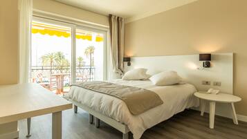 Une chambre d’hôtel avec un lit, une table de chevet et une vue sur le balcon extérieur.