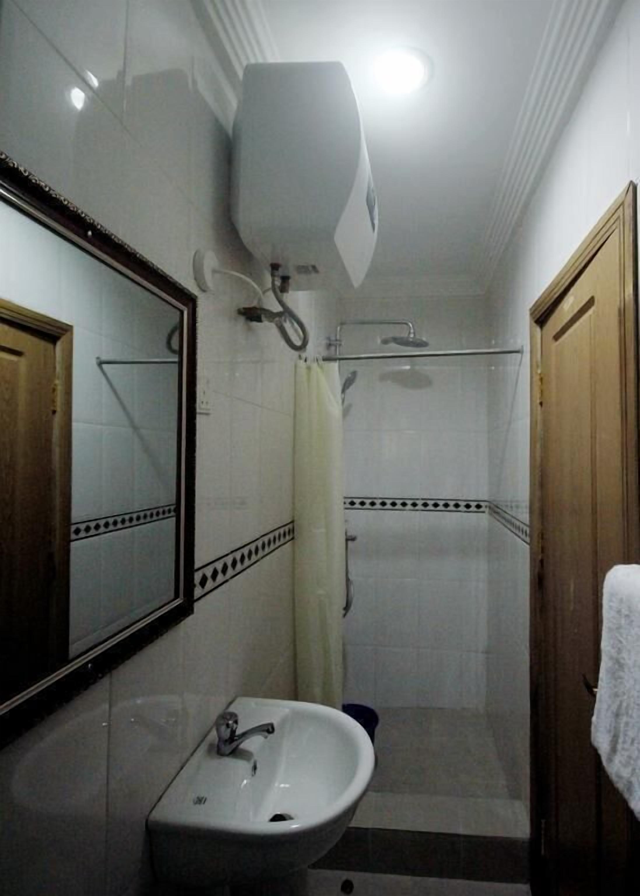 A bathroom with a sink, mirror, shower, and toilet.