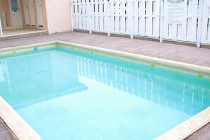 A rectangular swimming pool with a tiled edge and a white fence surrounding it. - Marley Manor (Kingston)