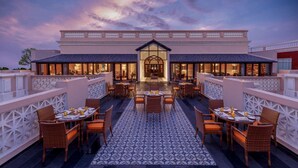 A hotel with a spacious outdoor dining area, a central entrance, and a patterned floor. - Welcomhotel by ITC Hotels, Raja Sansi, Amritsar (Amritsar)