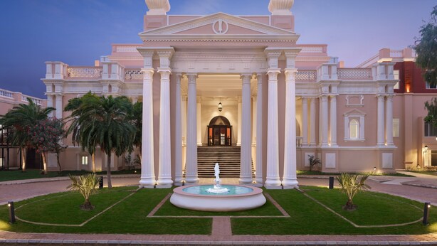A grand building with a central fountain, symmetrical columns, and a formal entrance. - Welcomhotel by ITC Hotels, Raja Sansi, Amritsar (Amritsar)