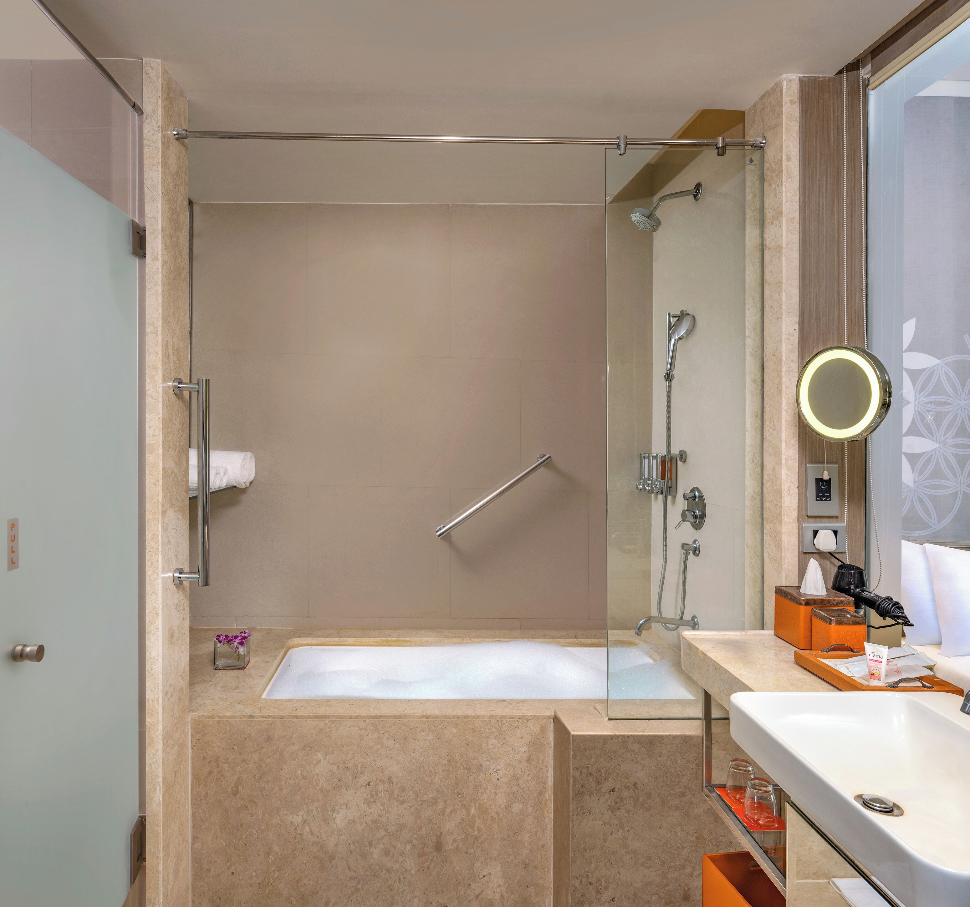 A modern bathroom with a glass-enclosed shower, a bathtub, and a vanity with a mirror.