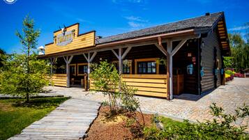 A Western-themed building with a wooden facade, a covered porch, and a sign reading "TOILET".