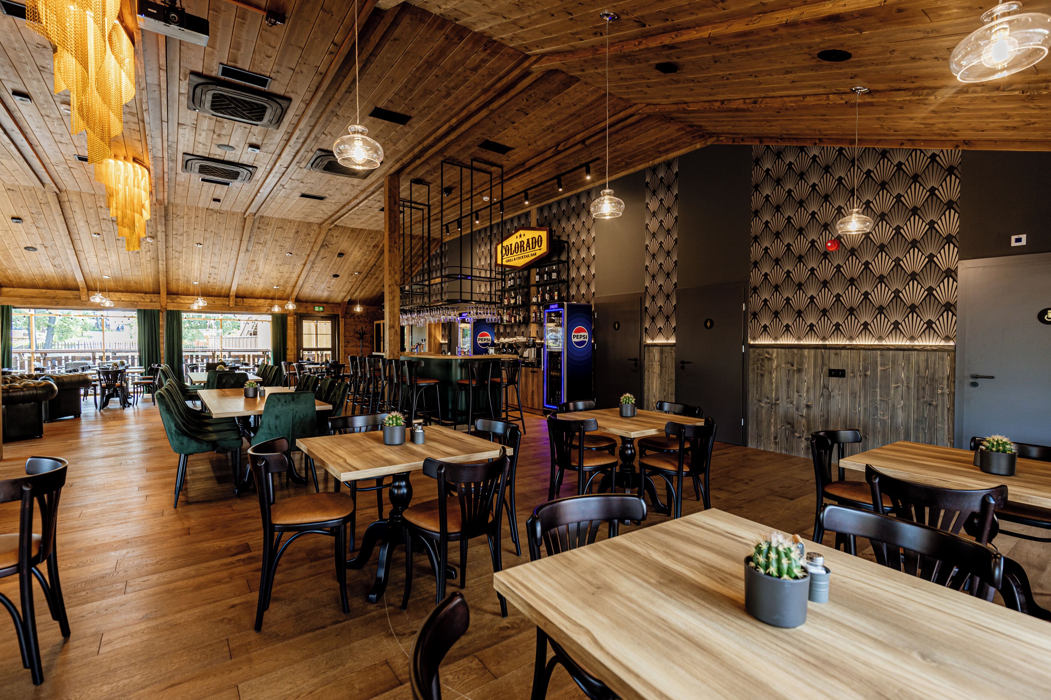 Un restaurante con interiores de madera, mesas, sillas y una zona de bar.