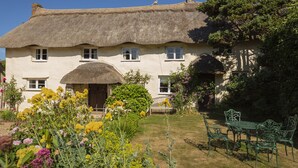 A traditional thatched-roof house with a garden in front. - Higher Collaton Cottage (Kingsbridge)