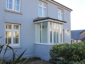 Stunning two-story residence with a bay window and beautifully maintained garden.