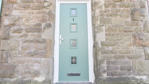 A stone building with a green door marked with the number 1. - No 1 Church Cottages (Llanelli)