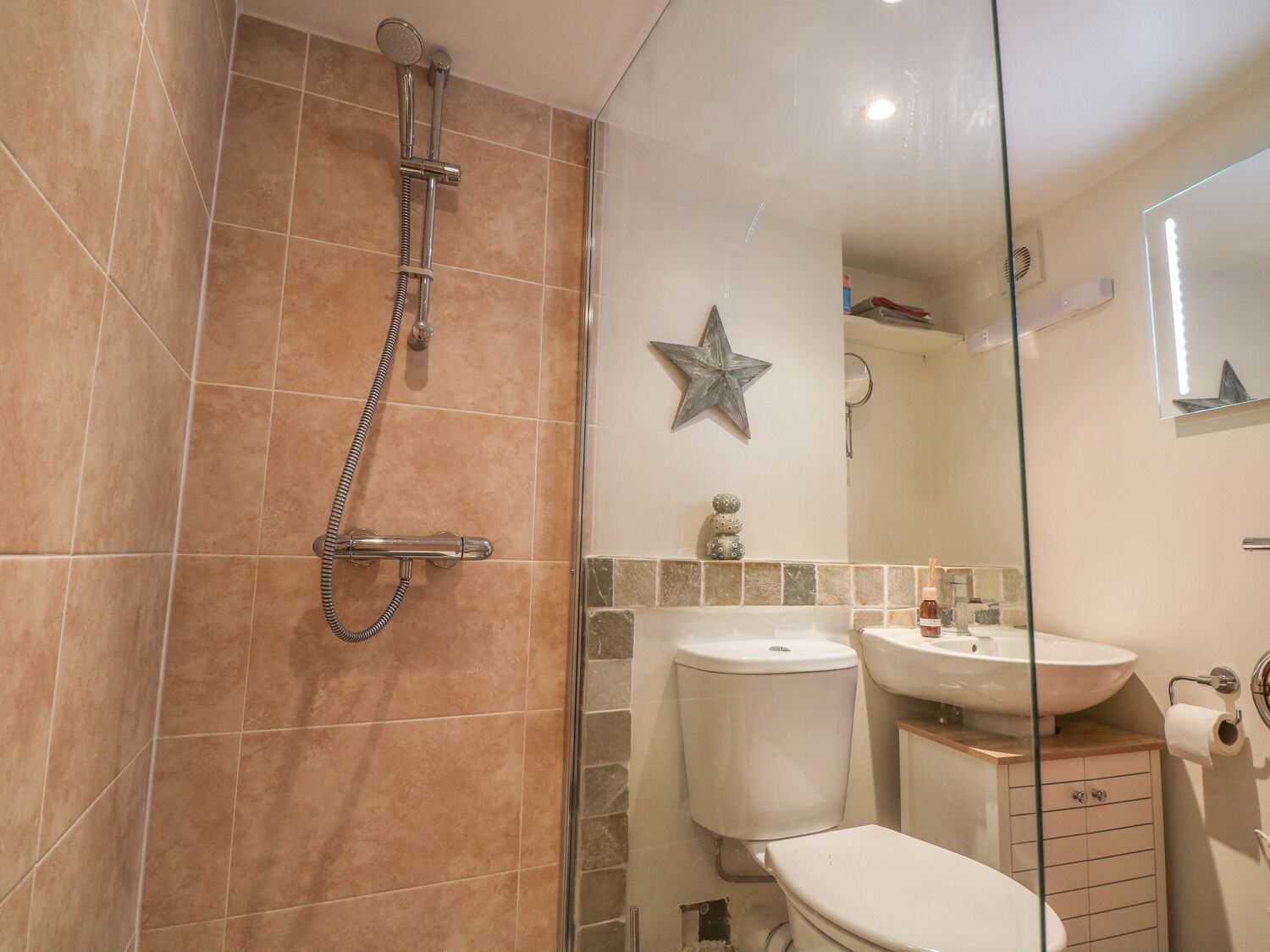 A bathroom with a shower, toilet, and sink.
