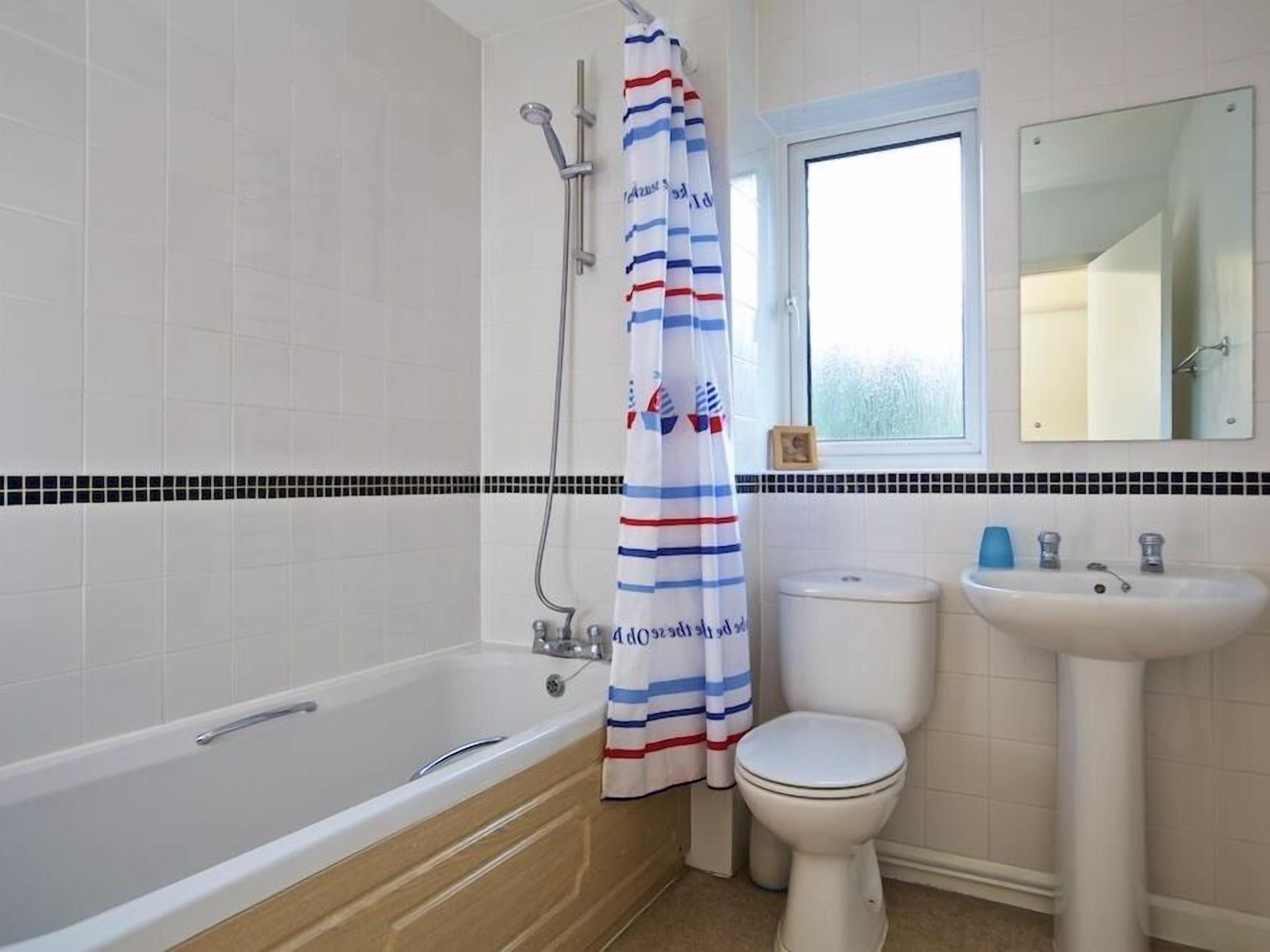 A bathroom with a bathtub, toilet, and sink.