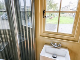 A bathroom with a window, a sink, and a shower.