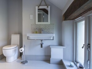 A bathroom with a toilet, sink, and mirror. - Rosemary Cottage (Kingsbridge)