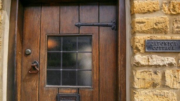 Una puerta de madera con un ventanal y una placa que dice 