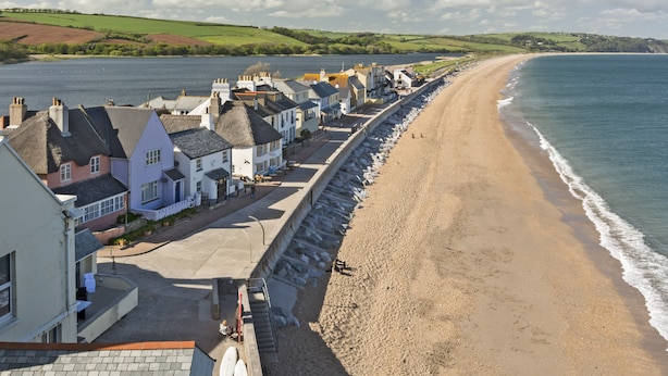 A coastal town with a sandy beach, houses with thatched roofs, and a clear view of the sea. - Cowslip Cottage (Kingsbridge)
