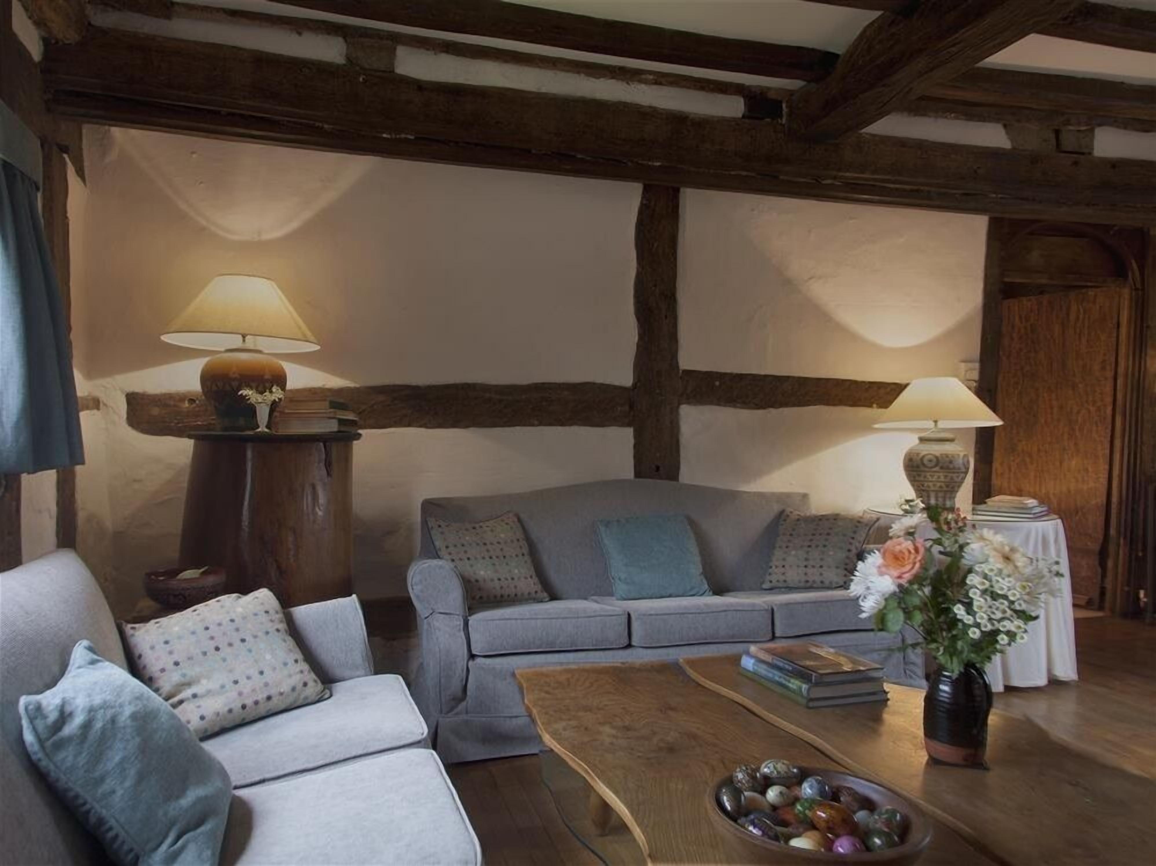 A cozy living room with a grey sofa, a wooden coffee table, and two lamps.