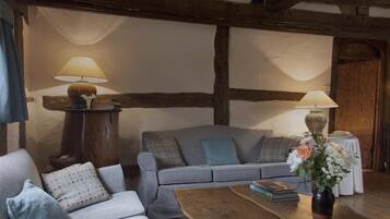 A cozy living room with a grey sofa, a wooden coffee table, and two lamps.