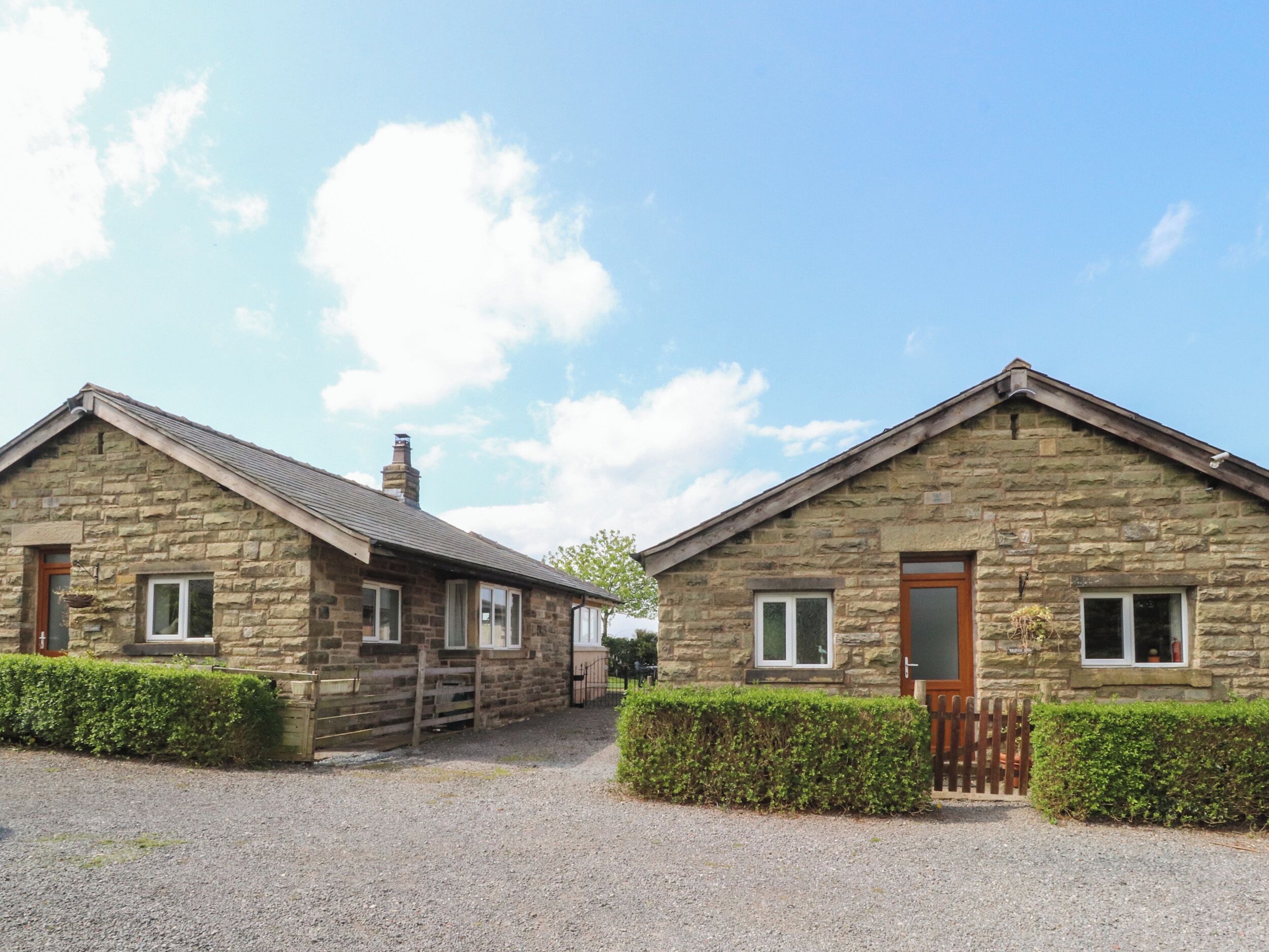 Two stone cottages with pitched roofs, wooden doors, and windows.