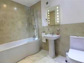 A bathroom with a bathtub, a sink, and a toilet. - The Old Mill (Mitcheldean)