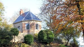 A stone house with a pitched roof, surrounded by trees and a grassy area. - The Folly at Castlebridge (Warminster)