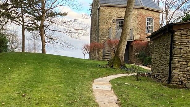 A stone pathway leading to a stone building with a window and a door. - The Folly at Castlebridge (Warminster)