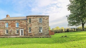 A stone building with a grassy lawn and a tree. - Godscroft Hall (Frodsham)