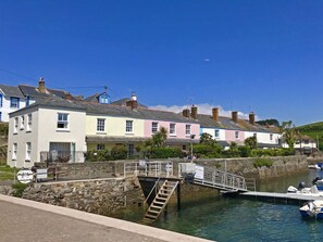 A waterfront property with a stone staircase leading to a dock, surrounded by colorful houses. - 3 Church Hill House (Salcombe)
