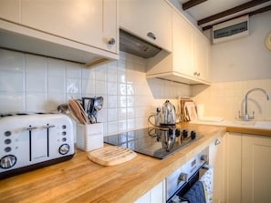 Fully equipped kitchen with oven, sink, and ample countertop space.