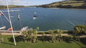 A marina with boats, a flag, and a grassy area with palm trees. - 36 The Salcombe (Salcombe)