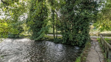 A river with a stone bridge and a wooden fence.