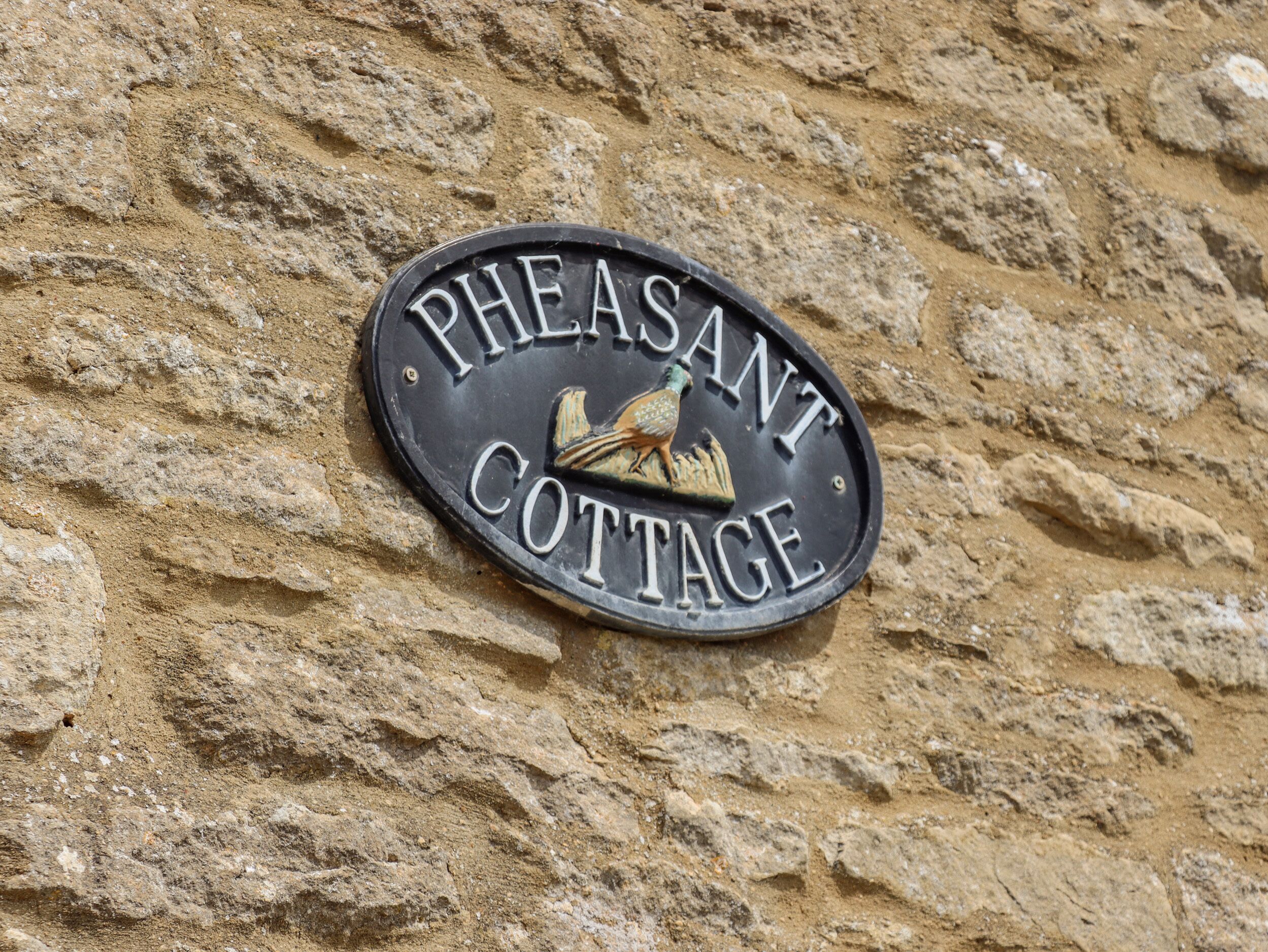 Skilt med teksten 'Pheasant Cottage' og en illustration af en fasan.