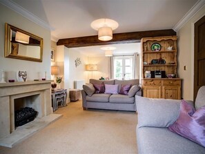 Relax in this inviting living room with a sofa, armchair, and fireplace.