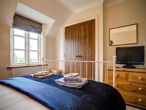 Relax in a spacious bedroom with a large bed, flat-screen TV, and a stylish wardrobe.