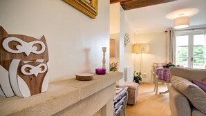 Un salon chaleureux avec une cheminée, un canapé et un coin repas comprenant une table et des chaises.