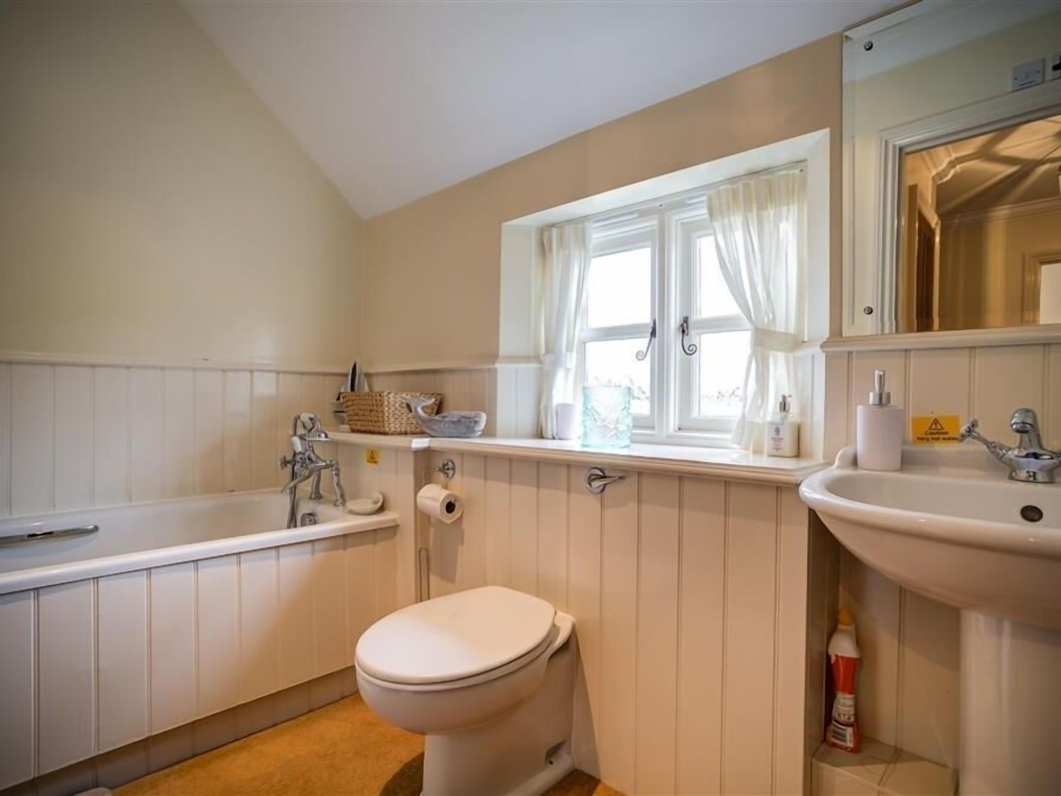 A bathroom with a bathtub, toilet, and sink.