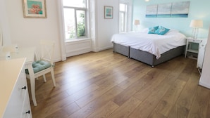A bedroom with a bed, bedside tables, a chair, and a desk. - Waverley House (Beaumaris)