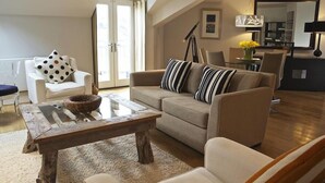 A modern living room with a sofa, armchairs, a coffee table, and a dining area with a table and chairs. - Diddly Squat, 43 Dart Marina (Dartmouth)