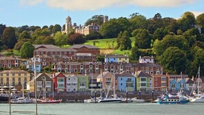 A coastal town with colorful houses, a marina with boats, and a historic building on a hill. - Diddly Squat, 43 Dart Marina (Dartmouth)