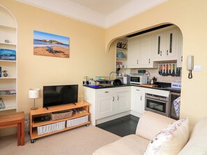 A compact living space with a television, kitchenette, and a bookshelf. - 3 Dartview (Dartmouth)
