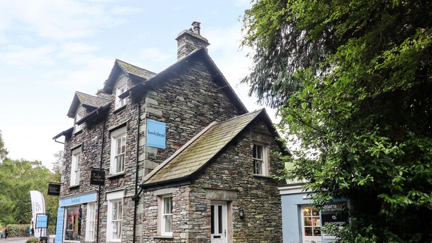 A stone building with multiple signs, including "Hawkshead" and "Judges Factory." - Shepherd's Crook (Ambleside)
