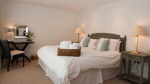 A neatly arranged bedroom with a bed, bedside tables, a desk, and a chair. - Homefield House (Kingsbridge)