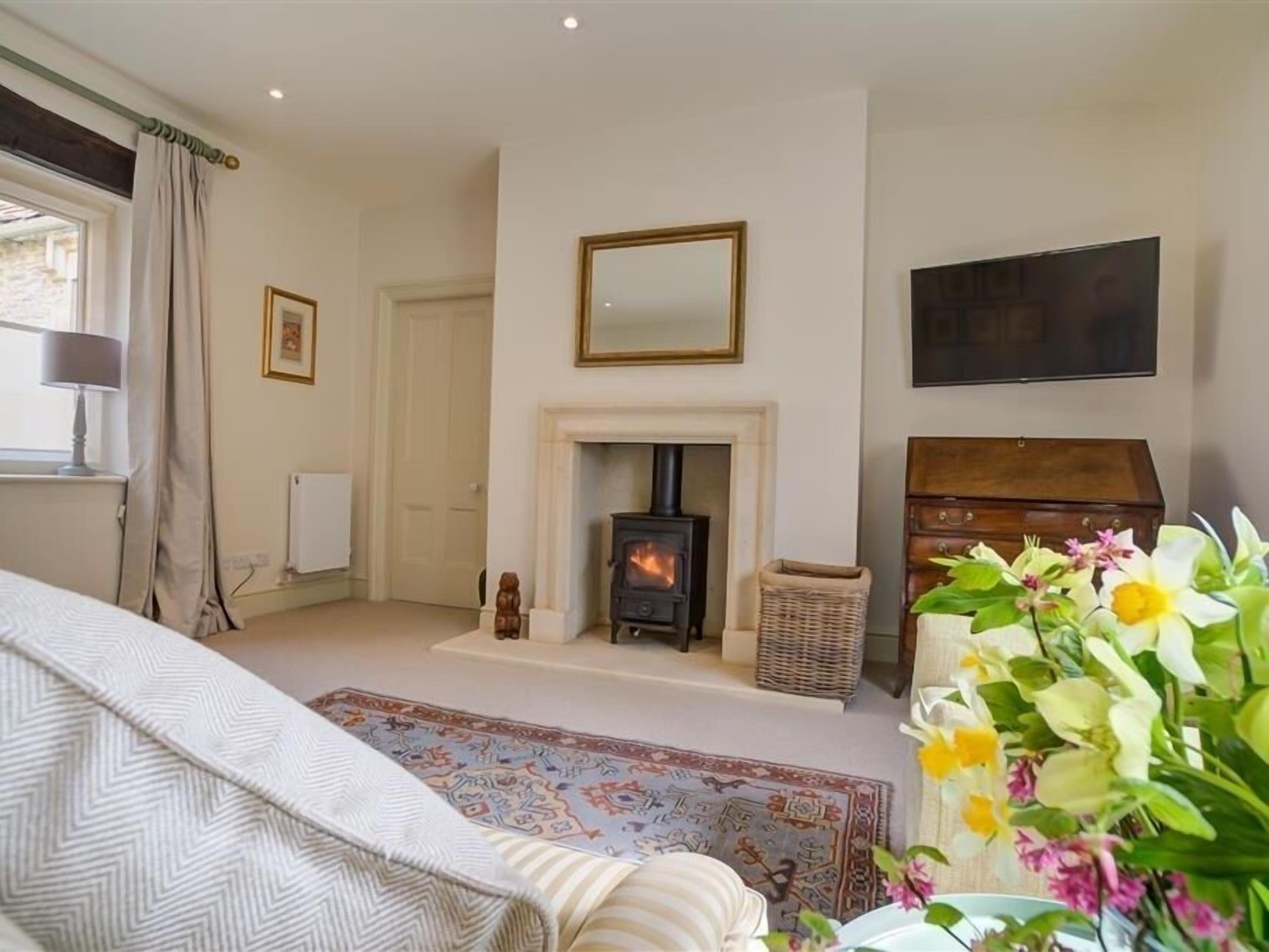 A cozy room with a fireplace, a television, and a bed with patterned bedding.