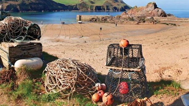 A beach with fishing nets, a basket of coconuts, and a wooden structure. - 4 Armada House (Kingsbridge)