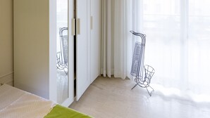 A bedroom with a bed, a wardrobe, a window with curtains, and a chair. - Beating Heart City Family Home Next to Beach (Chania)