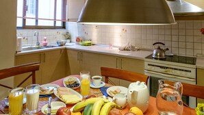 A breakfast table with various food items, a kettle, and a water pitcher. - Beating Heart City Family Home Next to Beach (Chania)