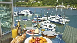 A dining table with breakfast items and a view of a marina with boats. - 7 Dart Marina (Dartmouth)