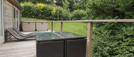 Eine Terrasse mit integriertem Grill und überdachter Sitzgelegenheit.
