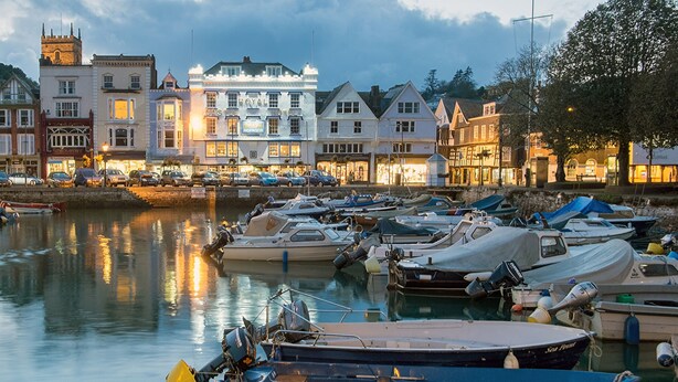 A marina with boats docked, a castle hotel, and traditional buildings along the waterfront. - Keepers Lodge, Hillfield Village (Dartmouth)