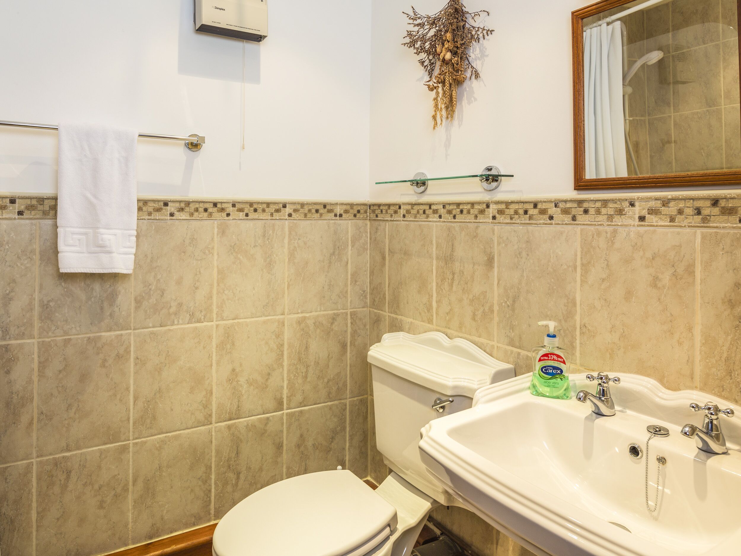 A bathroom with a toilet, sink, and shower.