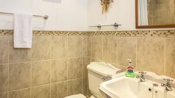 A bathroom with a toilet, sink, and shower.
