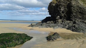 Une plage bordée de falaises rocheuses et dotée d’un rivage sablonneux.