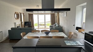 Une cuisine moderne avec un coin repas, un canapé et un téléviseur.